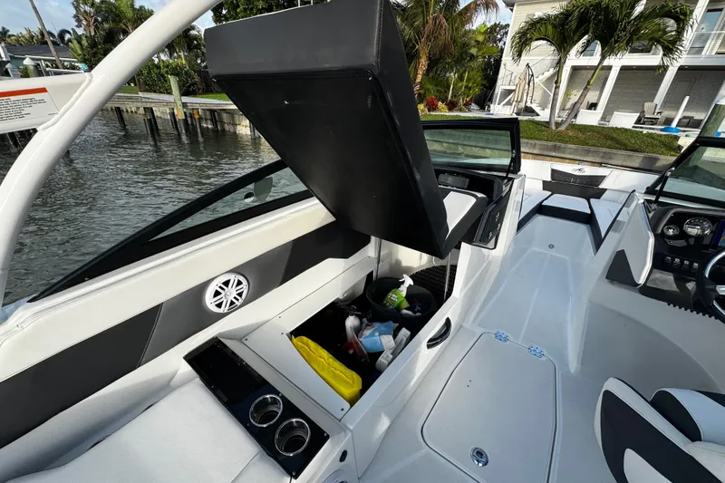 Slide: The Image of 2023 Monterey M-225 boat interior with open storage compartment, cup holders, and sleek design. - 22