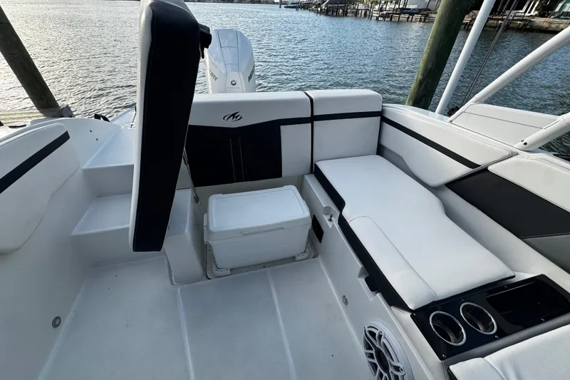 Slide: The Image of 2023 Monterey M-225 boat interior with seating, cup holders, and water view. - 24