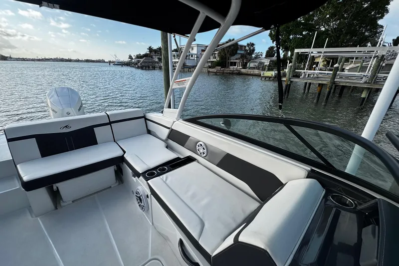 Slide: The Image of 2023 Monterey M-225 boat interior with seating, cup holders, and waterfront view. - 27