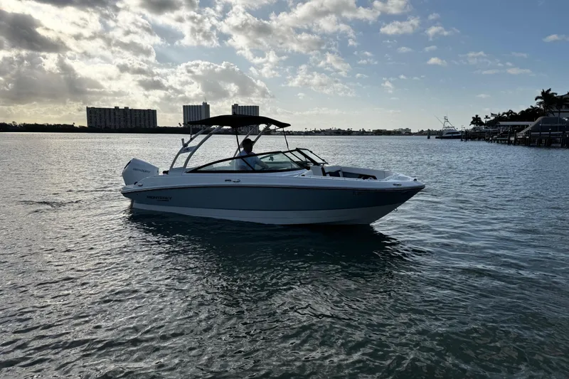 Slide: The Image of 2023 Monterey M-225 boat cruising on a calm waterway under a partly cloudy sky. - 3