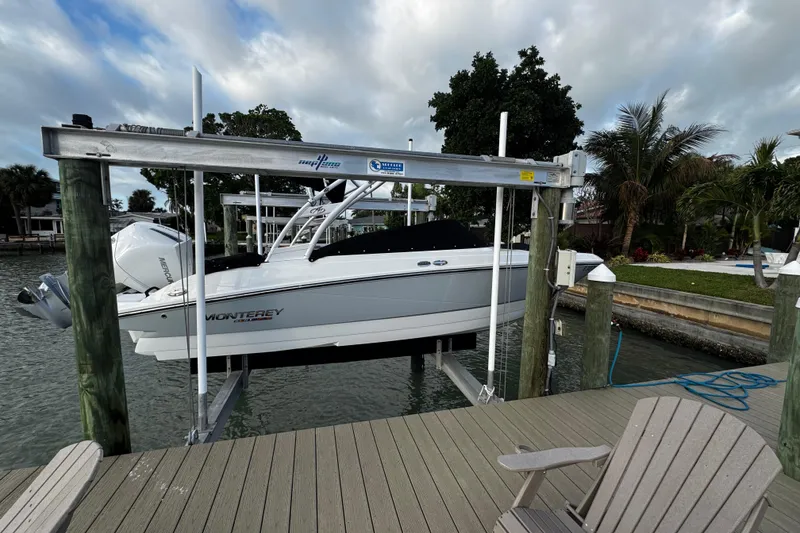 Slide: The Image of 2023 Monterey M-225 boat on lift at dockside, surrounded by tropical scenery. - 36
