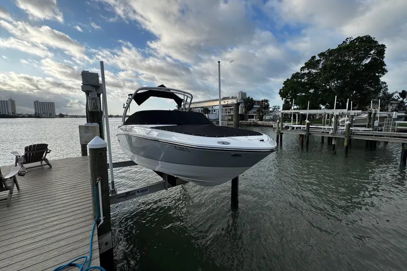 Slide: The Image of 2023 Monterey M-225 boat docked on a lift by a scenic waterfront. - 38