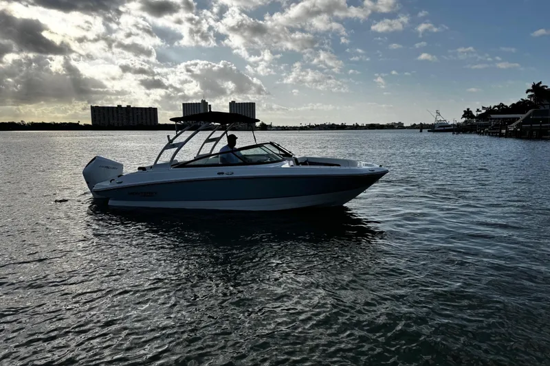 Slide: The Image of 2023 Monterey M-225 boat cruising on a calm waterway under a partly cloudy sky. - 4