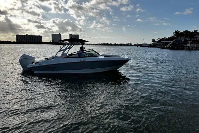 Slide: The Image of 2023 Monterey M-225 boat cruising on a calm waterway under a partly cloudy sky. - 5