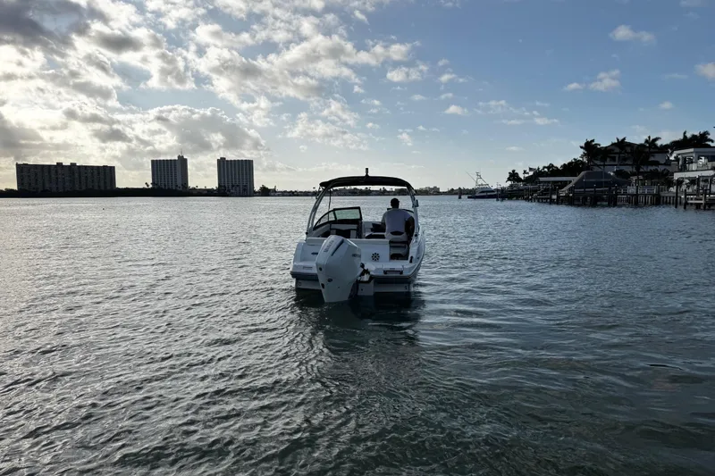 Slide: The Image of 2023 Monterey M-225 boat cruising on a calm waterway under a partly cloudy sky. - 8