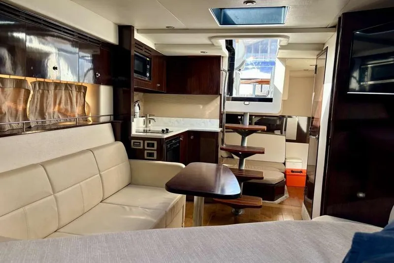 Slide: The Image of Interior of 2018 Sea Ray Sundancer 350 Coupe with modern furnishings and compact kitchen. - 11