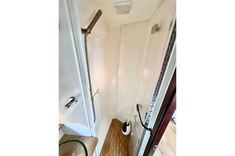 Slide: The Image of 2018 Sea Ray Sundancer 350 Coupe shower area with modern fixtures and wooden flooring. - 16