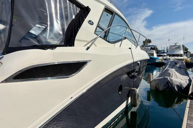 Slide: The Image of 2018 Sea Ray Sundancer 350 Coupe docked at marina under clear sky. - 21