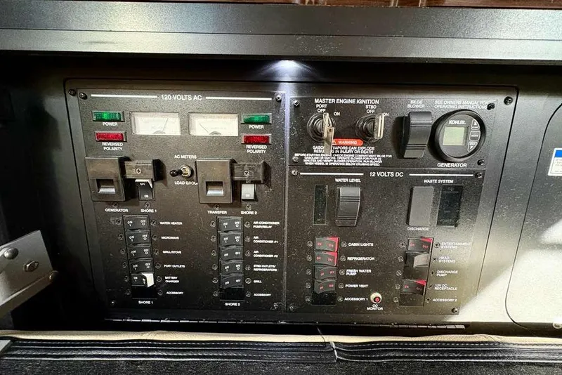 Slide: The Image of Control panel of a 2018 Sea Ray Sundancer 350 Coupe boat, showing various switches and meters. - 23