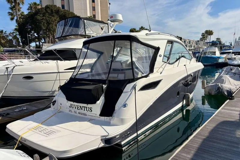 Slide: The Image of 2018 Sea Ray Sundancer 350 Coupe docked at marina, featuring sleek design and modern amenities. - 4