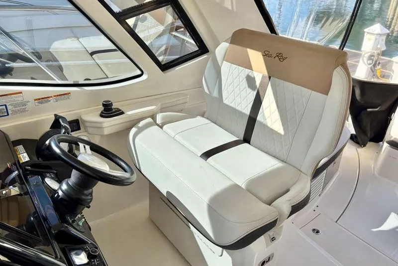 Slide: The Image of 2018 Sea Ray Sundancer 350 Coupe helm with luxurious seating and modern steering controls. - 7