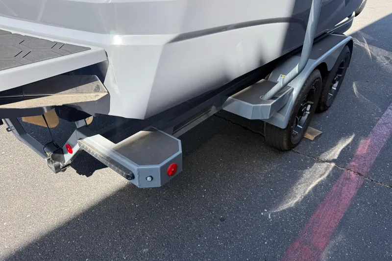 Slide: The Image of 2026 MasterCraft NXT22 boat trailer with dual axles on asphalt surface. - 10