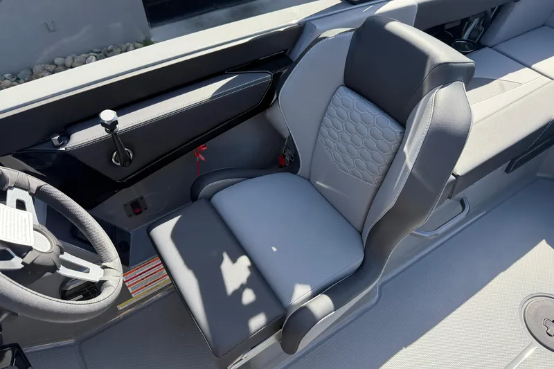 Slide: The Image of 2026 MasterCraft NXT22 boat interior with sleek, modern seating and steering wheel design. - 15