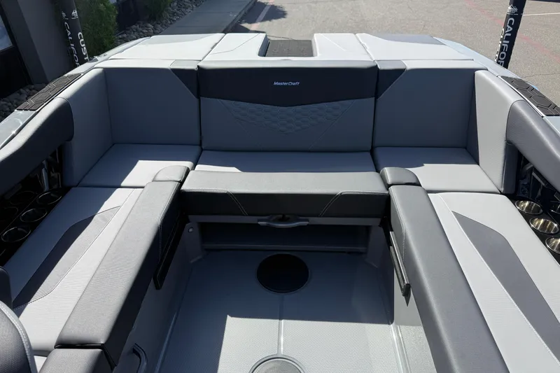 Slide: The Image of 2026 MasterCraft NXT22 boat interior with sleek gray seating and cup holders. - 18