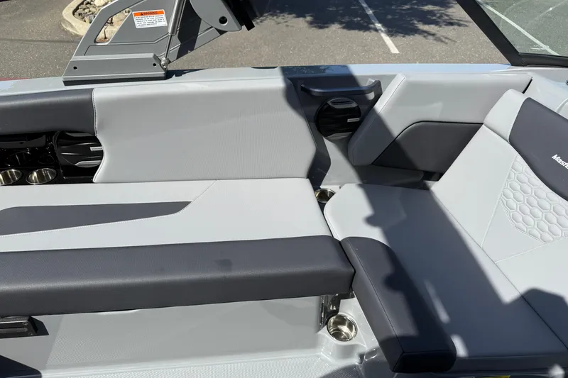 Slide: The Image of 2026 MasterCraft NXT22 boat interior with gray and black seating, cup holders, and modern design. - 21