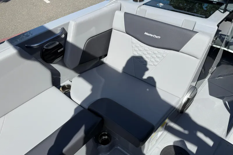 Slide: The Image of Interior seating of 2026 MasterCraft NXT22 boat with gray upholstery and cup holders. - 22