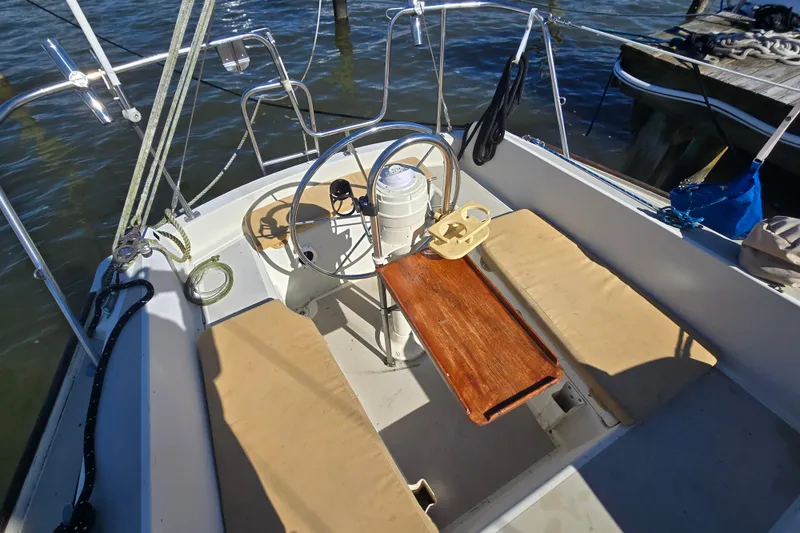Slide: The Image of 1985 O'Day 31 sailboat cockpit with steering wheel and wooden table. - 12