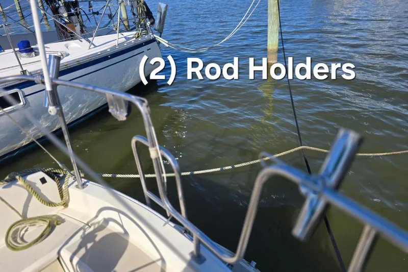 Slide: The Image of 1985 O'Day 31 sailboat with two rod holders, docked on calm water. - 14
