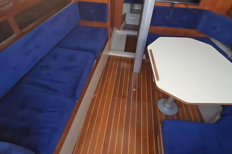 Slide: The Image of Interior of 1985 O'Day 31 sailboat with blue seating and wooden flooring. - 16