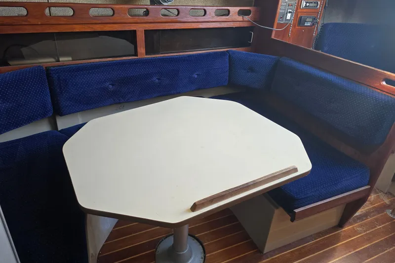 Slide: The Image of 1985 O'Day 31 sailboat interior with blue cushioned seating and white table. - 17