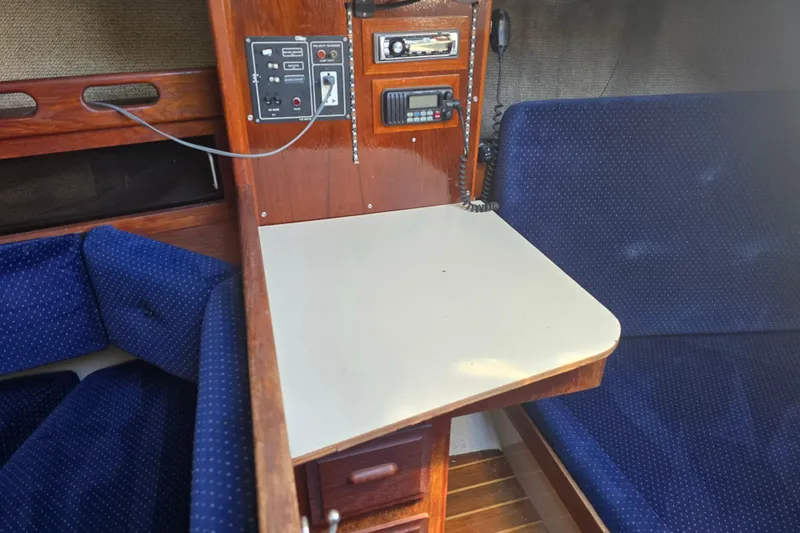 Slide: The Image of Interior of a 1985 O'Day 31 sailboat with blue seating and navigation equipment. - 19