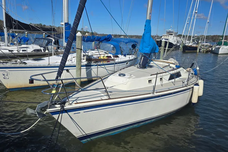 Slide: The Image of 1985 O'Day 31 sailboat docked in a marina, surrounded by other boats. - 2