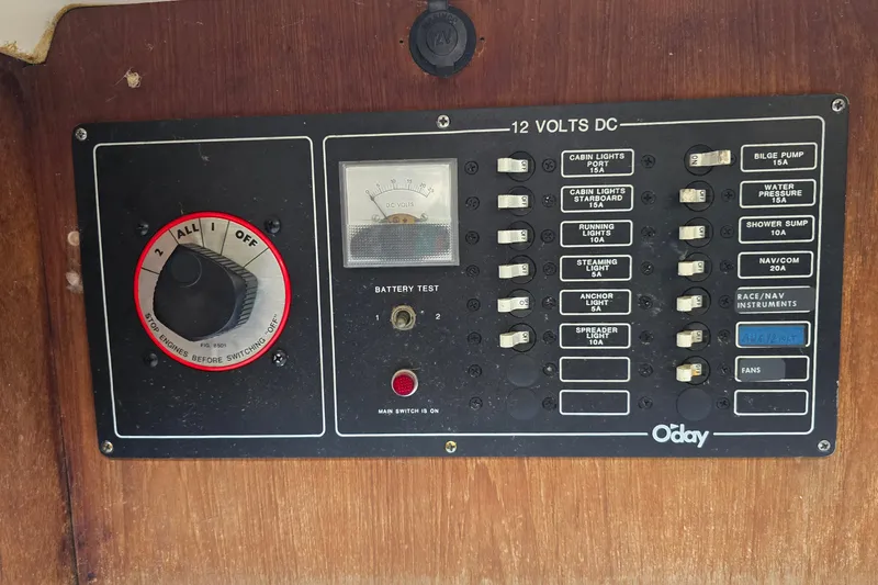 Slide: The Image of 1985 O'Day 31 sailboat electrical panel with switches and battery test gauge. - 21