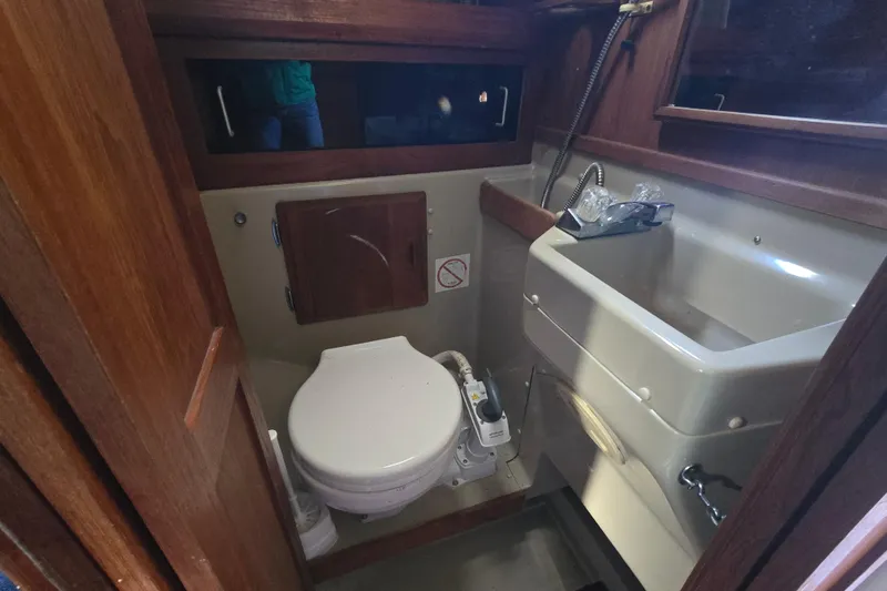 Slide: The Image of 1985 O'Day 31 sailboat bathroom with toilet, sink, and wooden accents. - 24