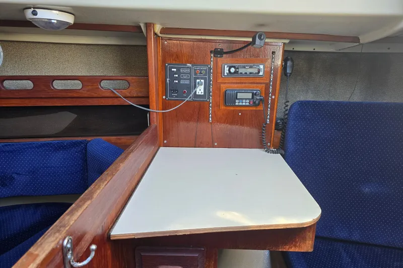 Slide: The Image of Interior of a 1985 O'Day 31 sailboat with navigation equipment and seating area. - 26