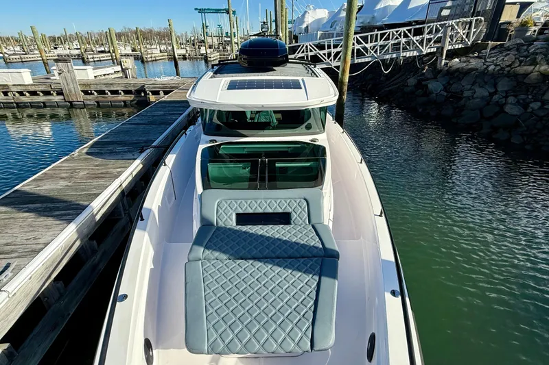 Slide: The Image of 2023 Axopar 37 Cross Cabin boat docked at marina, featuring sleek design and spacious deck. - 12