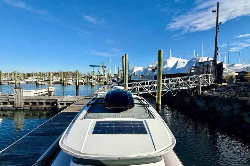 Slide: The Image of 2023 Axopar 37 Cross Cabin docked at a marina under clear blue skies. - 13