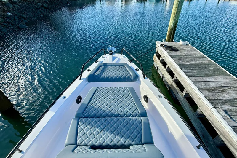 Slide: The Image of 2023 Axopar 37 Cross Cabin boat docked, featuring quilted seating and sleek design. - 16