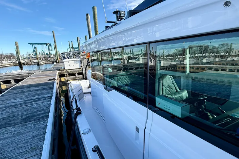 Slide: The Image of 2023 Axopar 37 Cross Cabin docked at marina under clear blue sky. - 17