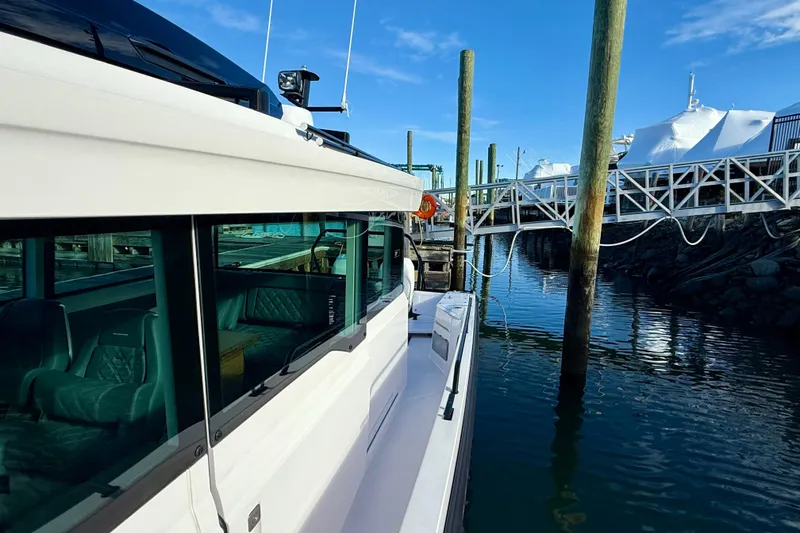Slide: The Image of 2023 Axopar 37 Cross Cabin docked at marina under clear blue sky. - 18