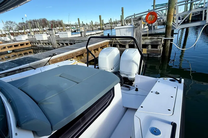 Slide: The Image of 2023 Axopar 37 Cross Cabin boat docked with dual engines and cushioned seating. - 20