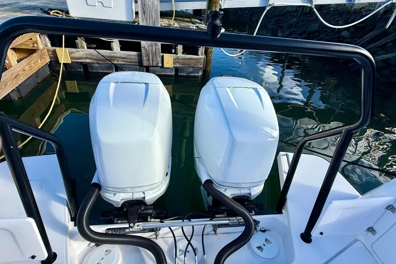 Slide: The Image of Twin outboard engines on a 2023 Axopar 37 Cross Cabin boat at a dock. - 23