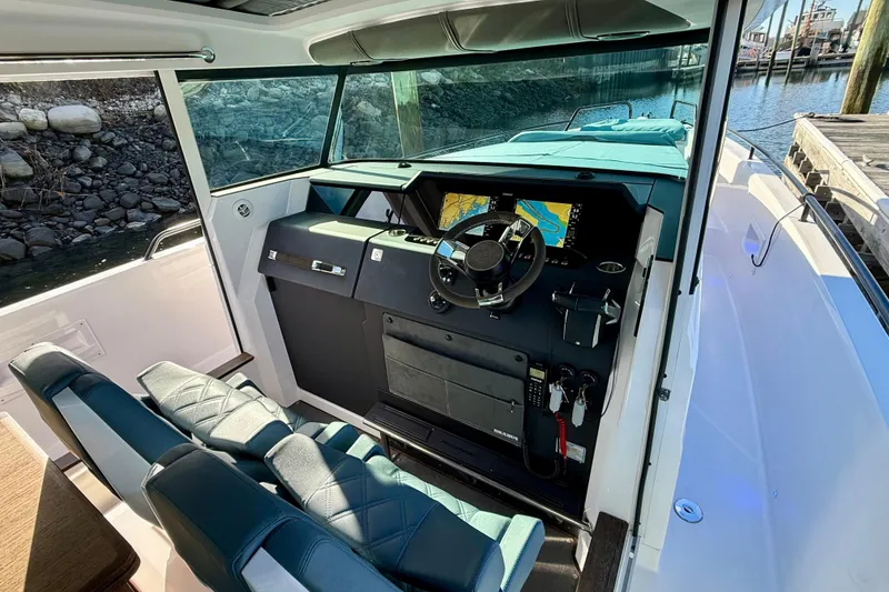 Slide: The Image of 2023 Axopar 37 Cross Cabin helm with modern navigation system and luxurious seating. - 28