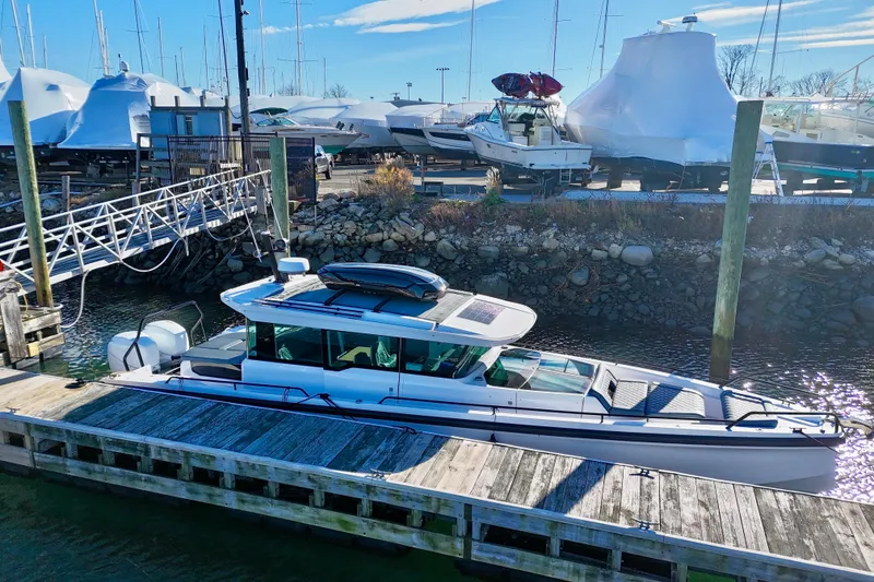 Slide: The Image of 2023 Axopar 37 Cross Cabin docked at a marina with other boats. - 3