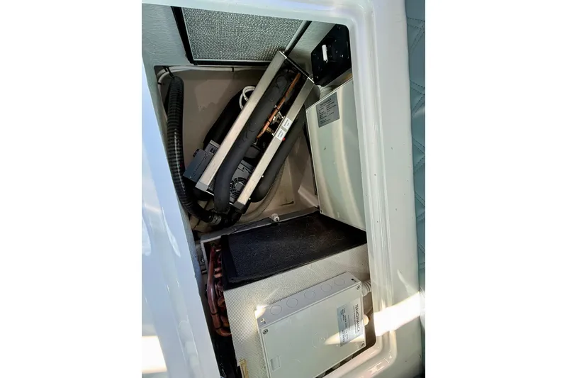 Slide: The Image of 2023 Axopar 37 Cross Cabin interior compartment with electrical components and wiring. - 35