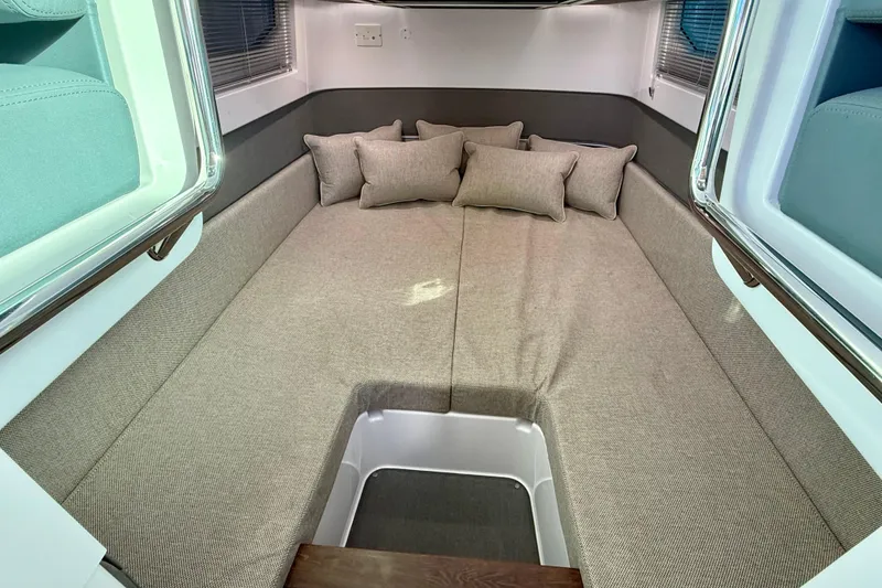 Slide: The Image of 2023 Axopar 37 Cross Cabin interior with cozy bedding and cushions. - 36