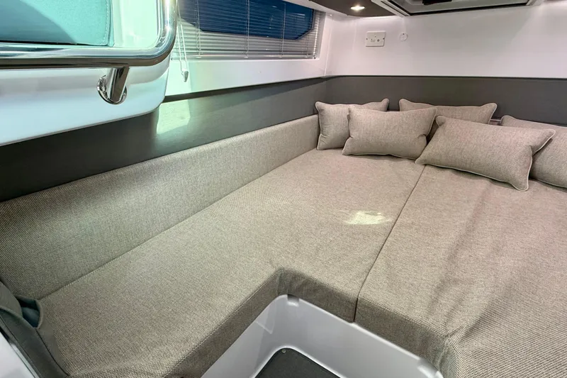 Slide: The Image of 2023 Axopar 37 Cross Cabin interior with cozy seating and cushions. - 37