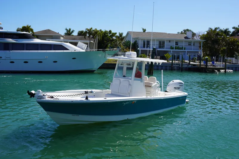 The Image of 2024 Regulator 26XO boat cruising in a sunny waterfront setting. - 0