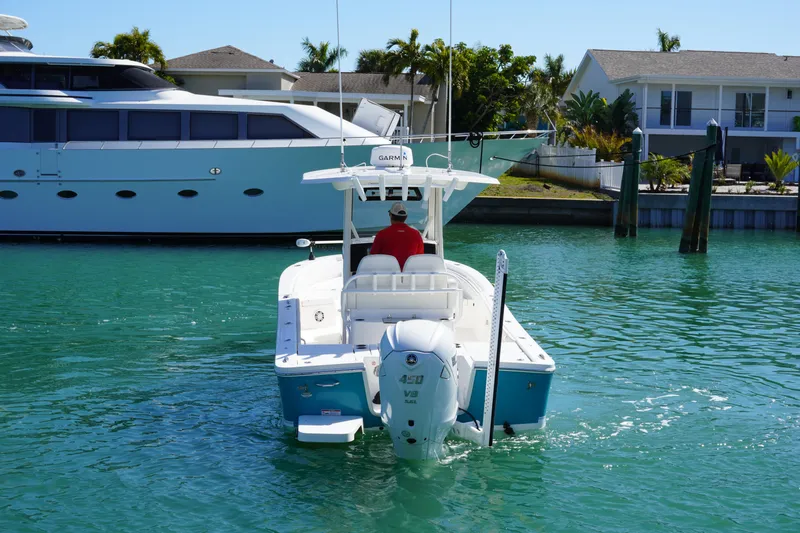 Slide: The Image of 2024 Regulator 26XO boat cruising in a marina with clear turquoise water. - 19