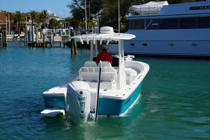 Slide: The Image of 2024 Regulator 26XO boat cruising in a marina with clear blue water. - 2