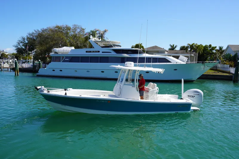 Slide: The Image of 2024 Regulator 26XO boat on clear water, with a yacht in the background. - 23