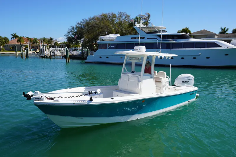 Slide: The Image of 2024 Regulator 26XO boat on turquoise water, docked near luxury yacht. - 25