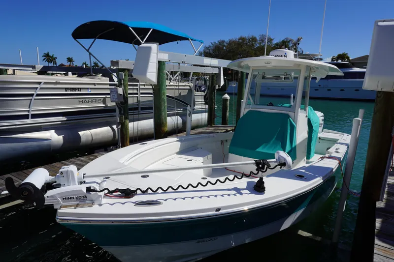 Slide: The Image of 2024 Regulator 26XO boat docked, featuring Minn Kota trolling motor and teal covers. - 30