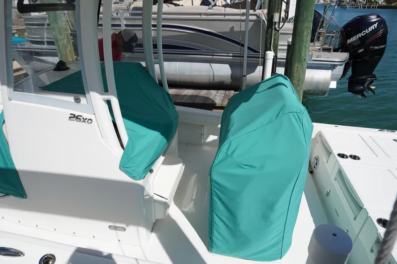 Slide: The Image of 2024 Regulator 26XO boat with teal seat covers docked by the water. - 31