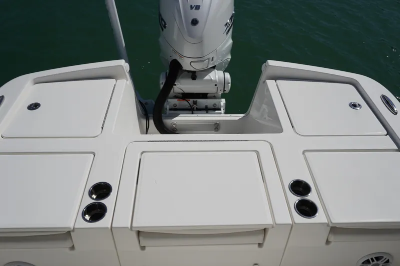 Slide: The Image of 2024 Regulator 26XO boat stern with outboard motor and storage compartments. - 35