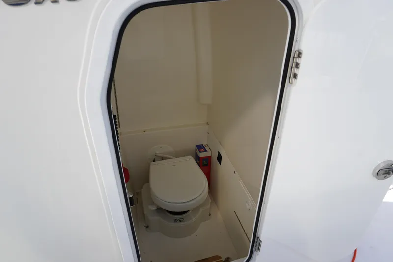 Slide: The Image of 2024 Regulator 26XO boat interior with compact marine toilet. - 37